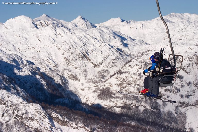 Skiers on chairlift at Vogel Ski resort in Slovenia.