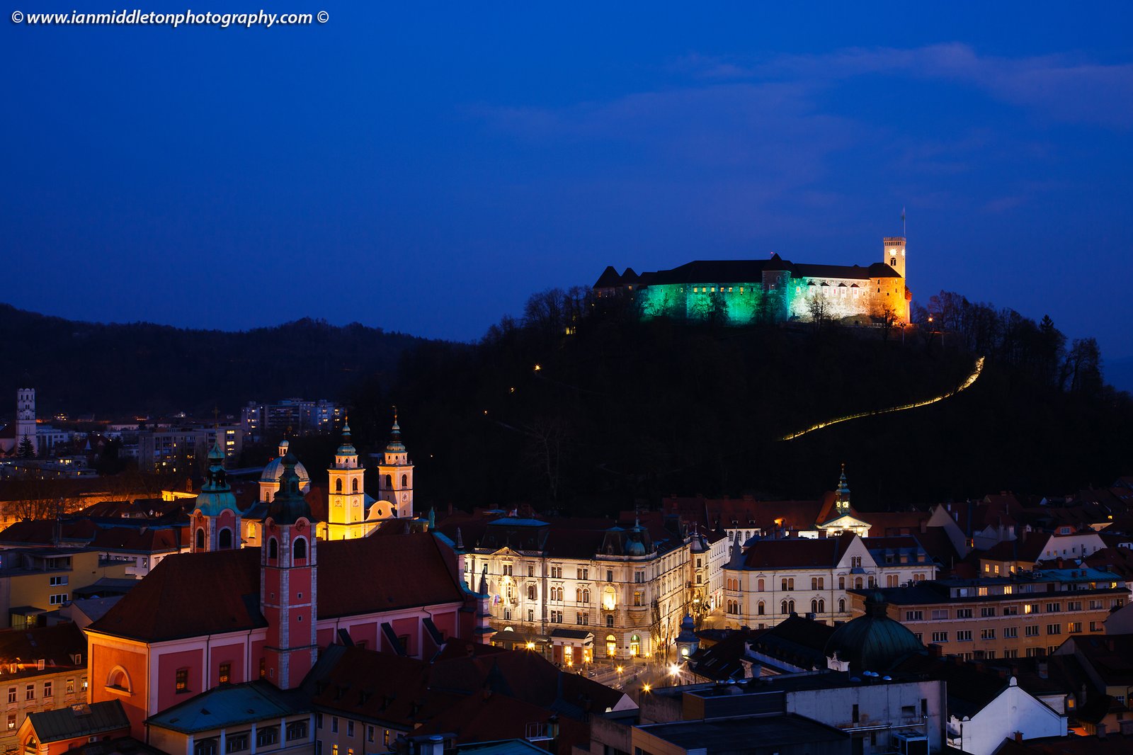 View down to the centre of Ljubljana and the Ljubljana Castle lit up in the colours of the Irish flag to celebrate Saint Patrick's Day weekend 2016 in Slovenia. The castle was lit up green last year to celebrate the event, but as Ljubljana is the European Green Capital for 2016 the castle is already being lit green at night for the whole year. So the Irish embassy arranged for the colours of the flag to adorn the castle for 2016.