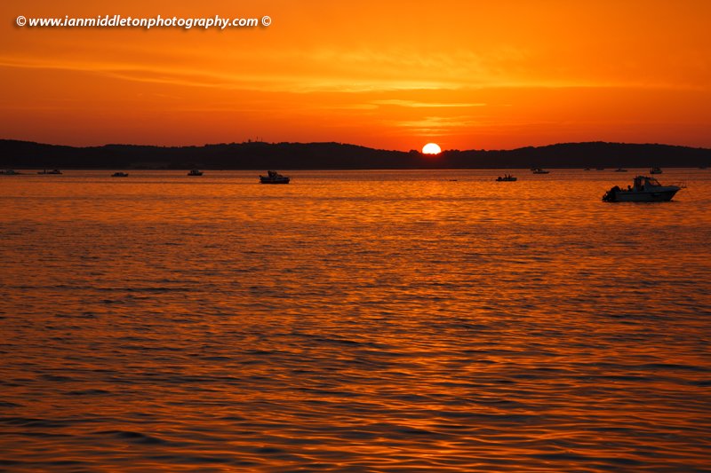 Fishing boats at sunset over the Brijuni Islands, Croatia. Seen from Puntižela Beach, Štinjan north of Pula.