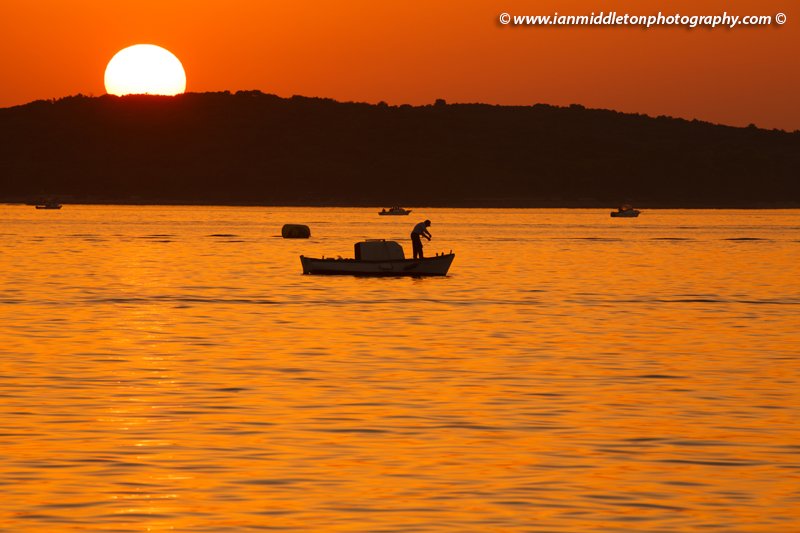 Fishing boats at sunset over the Brijuni Islands, Croatia. Seen from Puntižela Beach, Štinjan north of Pula.