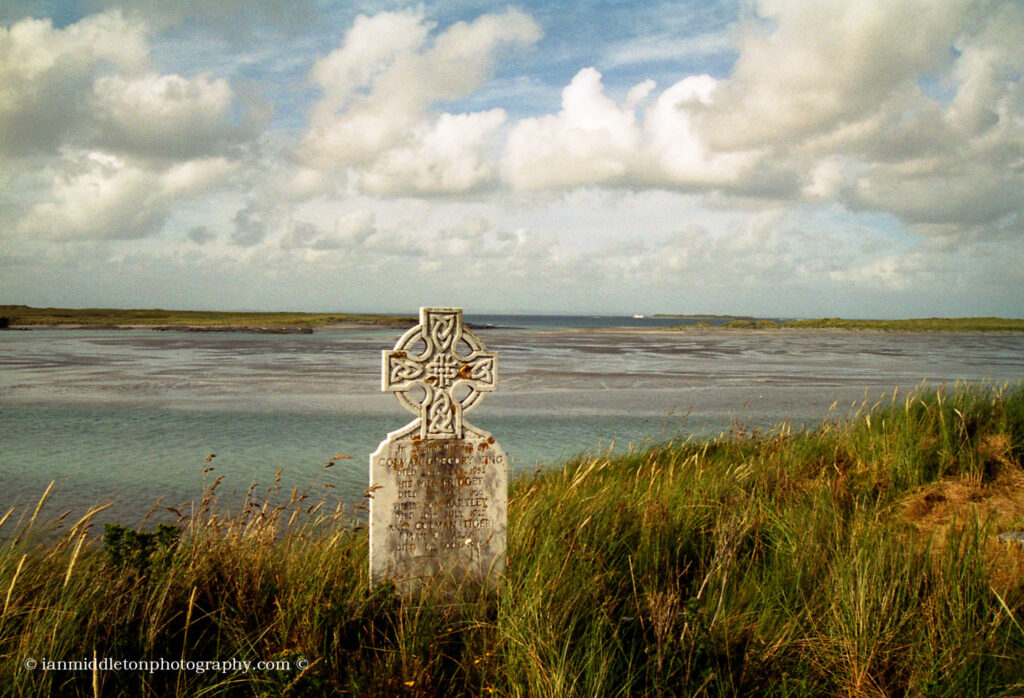 View of the coast and a Celtic Cross from St Enda's church on Inishmore, County Galway, Ireland.